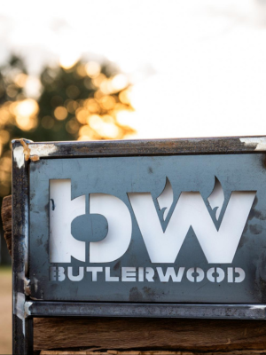a butlerwood branded metal firewood rack outside 